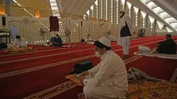 Umat muslim menjaga jarak saat mereka berkumpul untuk beritikaf di Masjid Agung Faisal di Islamabad, Pakistan, Kamis (14/5/2020). Itikaf adalah berdiam diri di masjid dengan niat beribadah untuk mendekatkan diri kepada Allah swt pada sepuluh hari terakhir bulan Ramadan. (Aamir QURESHI/AFP)