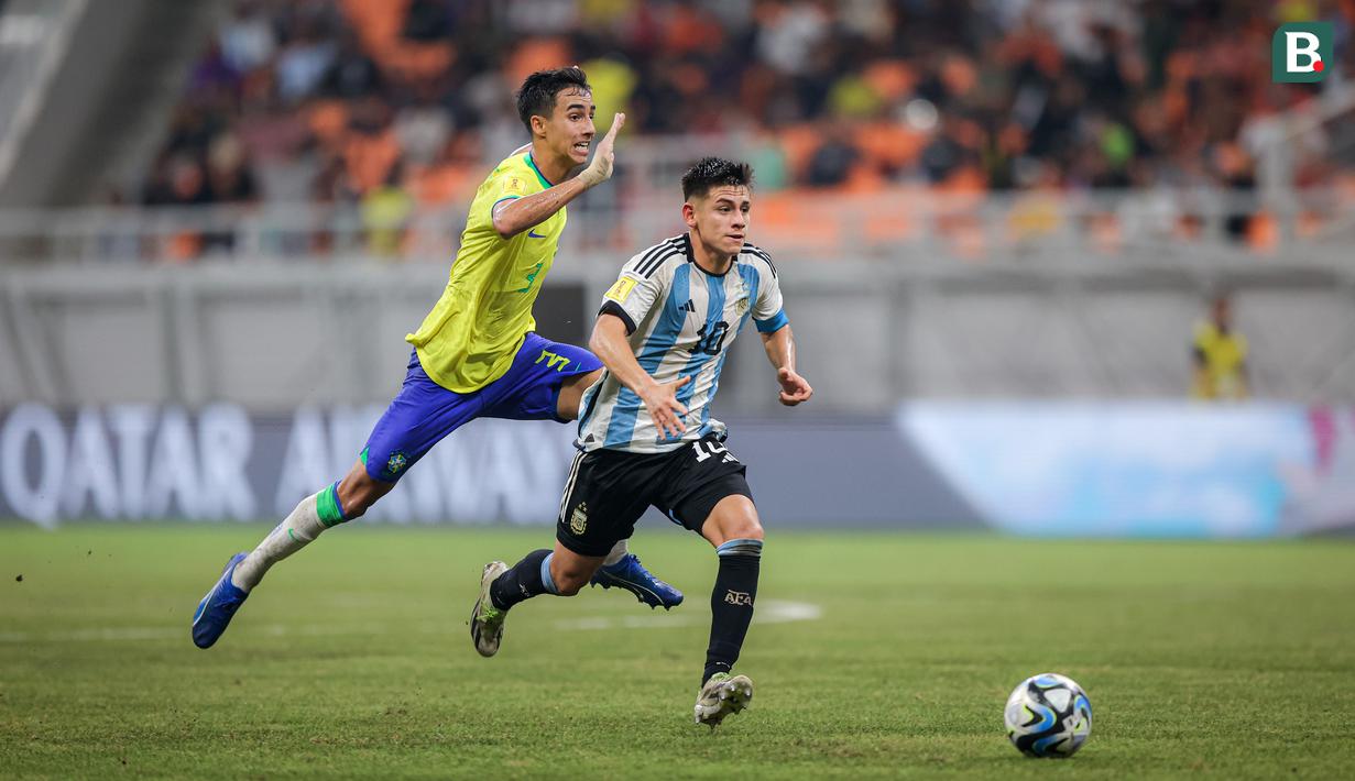 <p>Pemain Timnas Argentina U-17, Claudio Echeverri (kanan),&nbsp;mengontrol bola dibayangi pemain Brasil U-17, Vitor Reis dalam pertandingan perempat final Piala Dunia U-17 2023 yang berlangsung di Jakarta International Stadium, Jumat (24/11/2023). (Bola.com/Bagaskara Lazuardi)</p>