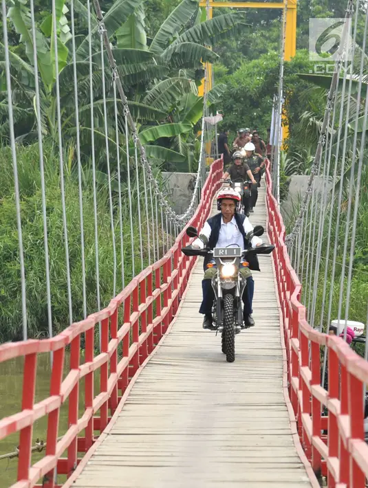 Presiden Joko Widodo mengendarai motor trail melintasi jembatan di Muara Gembong, Bekasi (1/11). Jokowi menghadiri kegiatan Perhutanan Sosial untuk Pemerataan Ekonomi. (Liputan6.com/Biro Pers Kepresidenan/Agus Suparto)