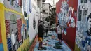 Anak-anak berswafoto di salah satu gang yang penuh mural 3D di Kampung Sehat, Utan Kayu Selatan, Jakarta, Rabu (11/11/2020). (merdeka.com/Iqbal S. Nugroho)