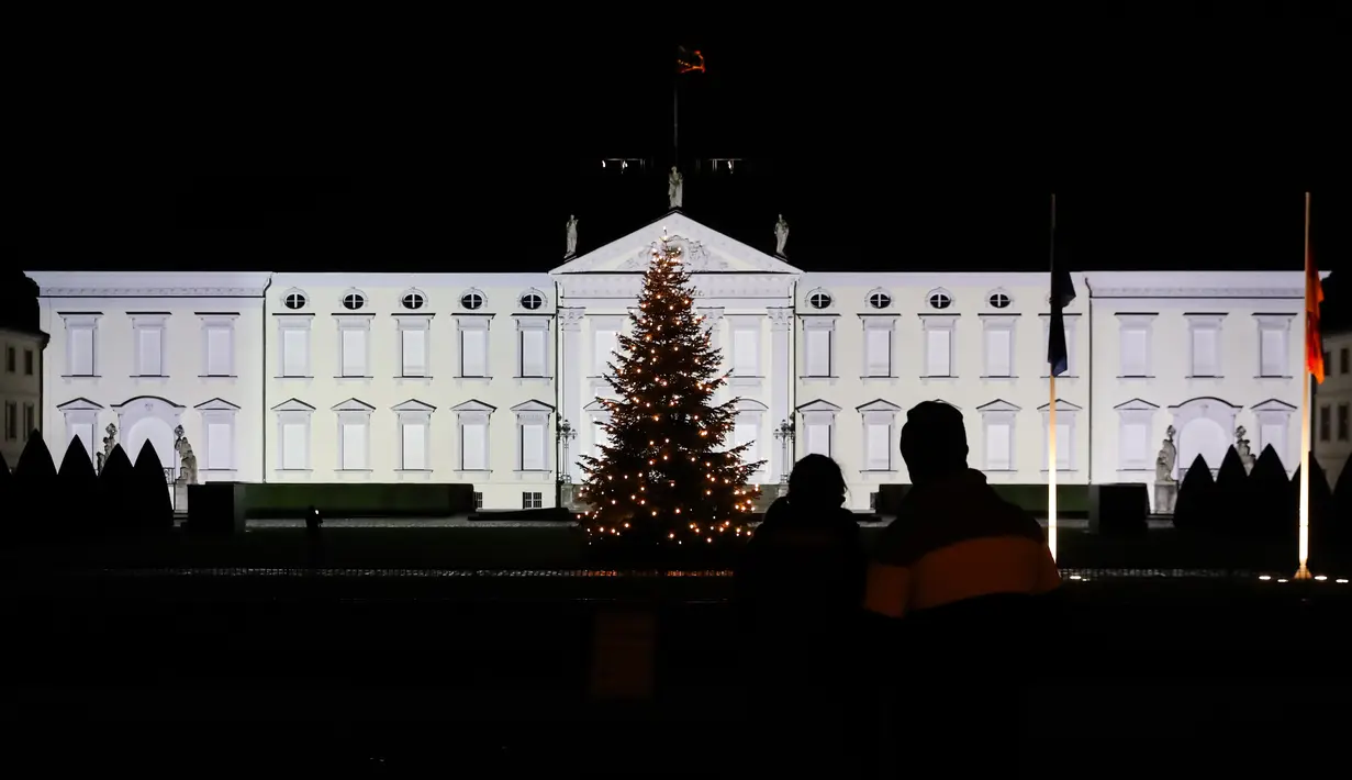 Pengunjung menikmati pemandangan Istana Bellevue dalam pertunjukan proyeksi cahaya di Berlin, ibu kota Jerman, pada 17 Desember 2020. Pertunjukan cahaya bertema "Lichtblick" (Seberkas Harapan) ini digelar di Istana Bellevue di Berlin. (Xinhua/Shan Yuqi)