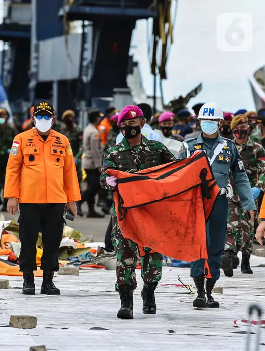 Prajurit TNI membawa kantong jenazah korban pesawat Sriwijaya Air PK-CLC nomor penerbangan SJ-182  yang jatuh di perairan Pulau Seribu, di Dermaga JICT, Jakarta, Selasa (12/1/2021). (Liputan6.com/Johan Tallo)