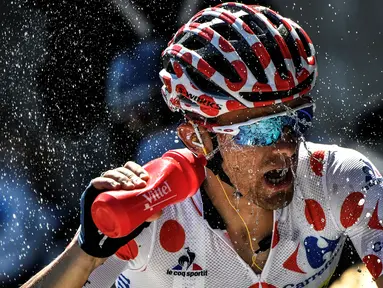 Pemegang kaus polkadot asal Polandia, Rafal Majka, menyemprotkan air ke wajahnya saat beraksi dalam Etape 17 Tour de France berjarak 184,5 km antara Berne dan Finhaut-Emosson, Prancis (20/7/2016). (AFP/Jeff Pachoud)