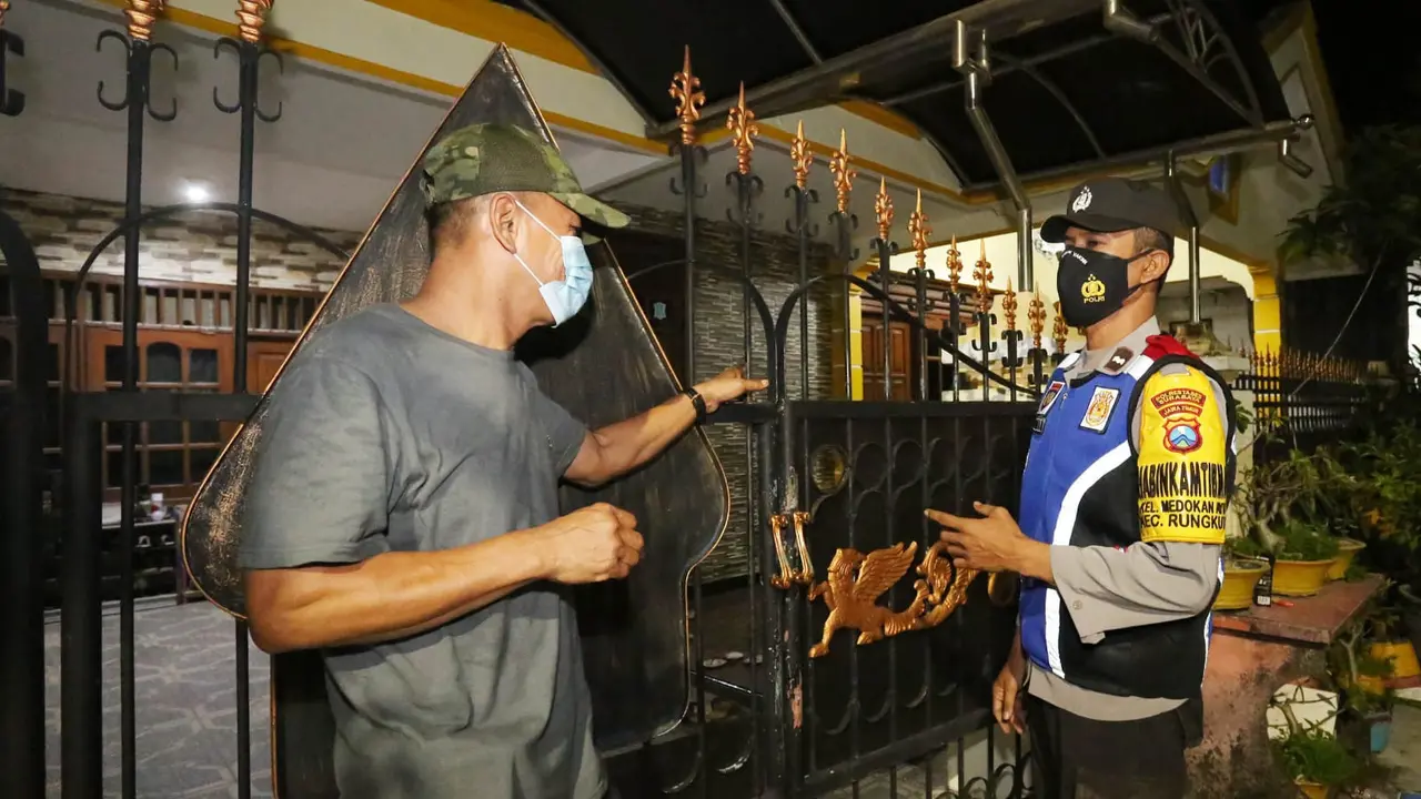 Anggota Binmas Polsek di Surabaya keliling memastikan keamanan rumah warga yang ditinggal mudik. (Dian Kurniawan/Liputan6.com)