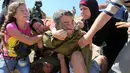 Foto yang diambil pada 28 Agustus 2015, Ahed Tamimi (kiri) berkelahi melawan tentara Israel saat terjadi bentrokan di Desa Nabi Saleh. Saat itu Ahed menggigit dan menampar tentara Israel yang menangkap saudara laki-lakinya. (AFP Photo/Abbas Momani)