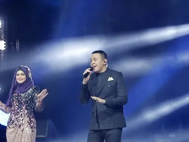 Penyanyi Siti Nurhaliza (kiri) berduet dengan Tulus dalam konser 'Dato Sri Siti Nurhaliza on Tour' di Istora Senayan, Jakarta, Kamis (21/2). Kehadiran Tulus menjadi kejutan spesial bagi penonton konser tersebut. (Fimela.com/Bambang E Ros)
