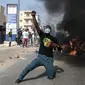 Seorang pendukung oposisi bereaksi di depan barikade yang terbakar selama demonstrasi yang diserukan oleh partai-partai oposisi di Dakar pada 4 Februari 2024. (Seyllou/AFP)