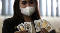 Pramuniaga menunjukkan emas batangan PT Aneka Tambang (Antam) Tbk di sebuah gerai emas, Jakarta, Senin (18/1/2021). Pada hari ini, harga emas Antam turun menjadi Rp 944 ribu per gram. (Liputan6.com/Johan Tallo)