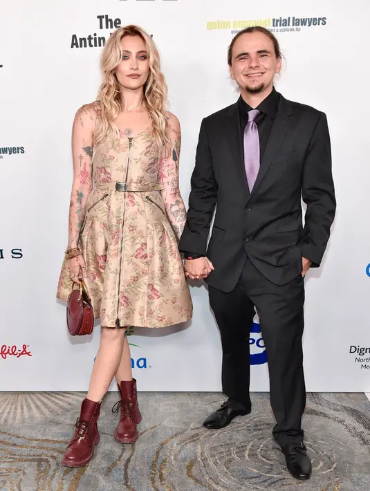 Paris Jackson (kiri) dan Prince Jackson (kanan) saat menghadiri Gala Harold and Carole Pump Foundation 2022 di The Beverly Hilton, Beverly Hills, California, Amerika Serikat, 19 Agustus 2022. Wanita berusia 24 tahun ini memilih gaun selutut dengan motif bunga dan sepatu bot merah marun. (Rodin Eckenroth/Getty Images/AFP)