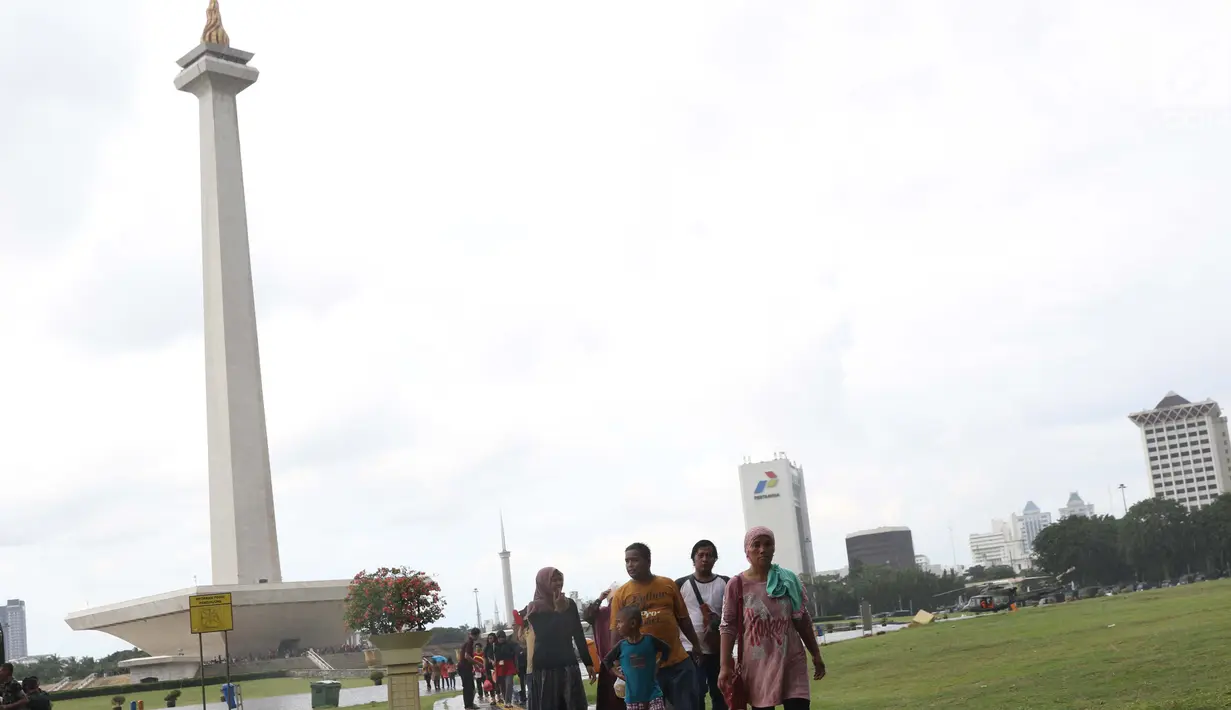 Warga berjalan-jalan di kawasan Monumen Nasional, Jakarta, Jumat (19/4). Libur panjang perayaan Paskah 2019 dimanfaatkan warga untuk berwisata di kawasan Monumen Nasional. (Liputan6.com/Helmi Fithriansyah)