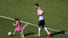 Waktu luang usai menjalani sesi latihan di Rio de Janeiro, (24/6/2014) dimanfaatkan oleh penyerang Timnas Belanda, Robin van Persie, untuk bermain bersama putrinya, Dina. (REUTERS/Ricardo Moraes)