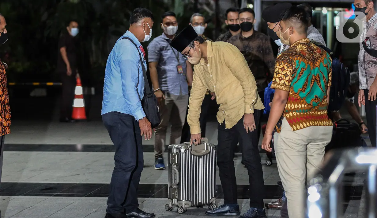Bupati Bangkalan Abdul Latif Amin Imron membawa koper dan dikawal saat tiba di Gedung Komisi Pemberantasan Korupsi (KPK), Jakarta, Rabu (7/12/2022). KPK menangkap Bupati Bangkalan Abdul Latif Amin Imron sebagai tersangka kasus suap lelang jabatan di Pemerintahan Kabupaten Bangkalan, Jawa Timur. Total kekayaan yang dimiliki Abdul Latif sebanyak Rp 9,9 miliar. (Liputan6.com/Johan Tallo)