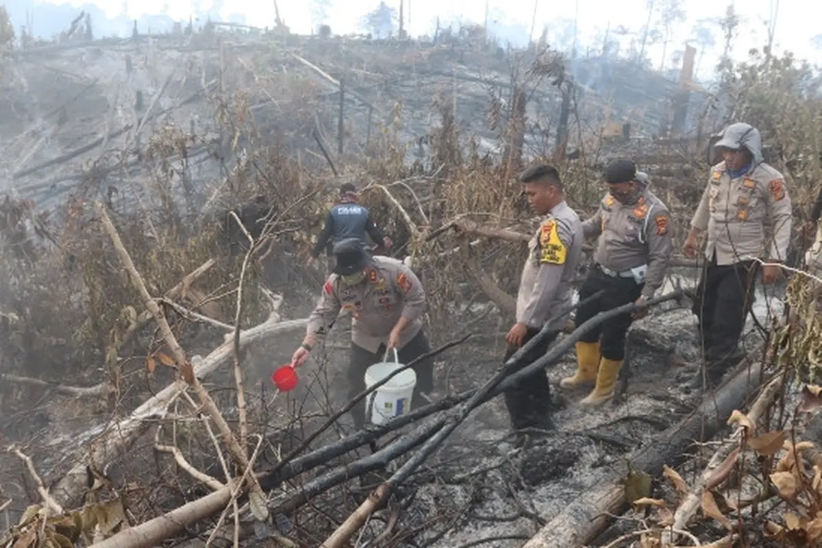 Polisi di Indragiri Hulu berusaha mendinginkan kebakaran lahan yang bisa memicu kabut asap Riau.
