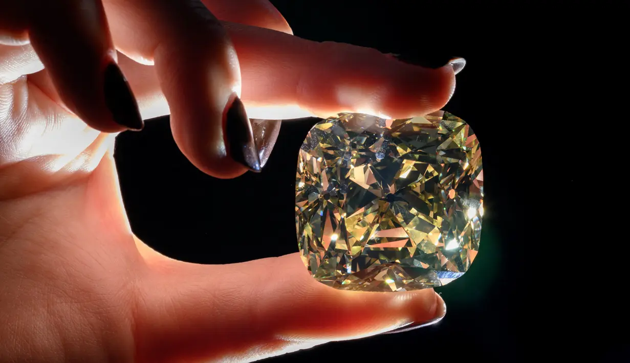 <p>'The Red Cross Diamond', sebuah berlian mewah berwarna kuning pekat berbentuk bantal dengan berat 205,07 karat yang akan ditawarkan oleh Rumah Lelang Christie di Jenewa, Swiss, 11 Mei 2022. Sebagian dari hasil penjualan berlian akan disumbangkan kepada Komite Palang Merah Internasional. (Fabrice COFFRINI/AFP)</p>