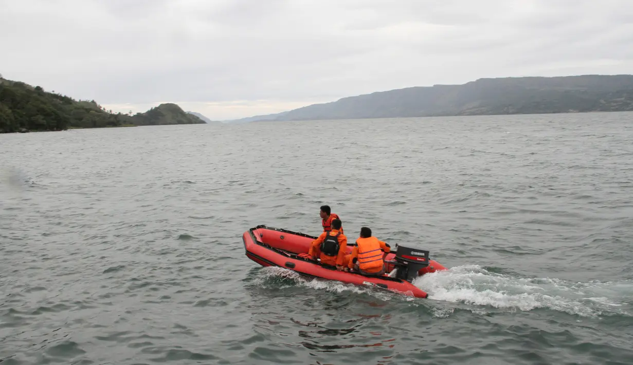 Tim penyelamat mencari korban hilang KM Sinar Bangun yang tenggelam di Danau Toba, Sumatera Utara, Selasa (19/6). Pencarian korban hilang sempat dihentikan akibat cuaca buruk. (AP Photo/Lazuardy Fahmi)