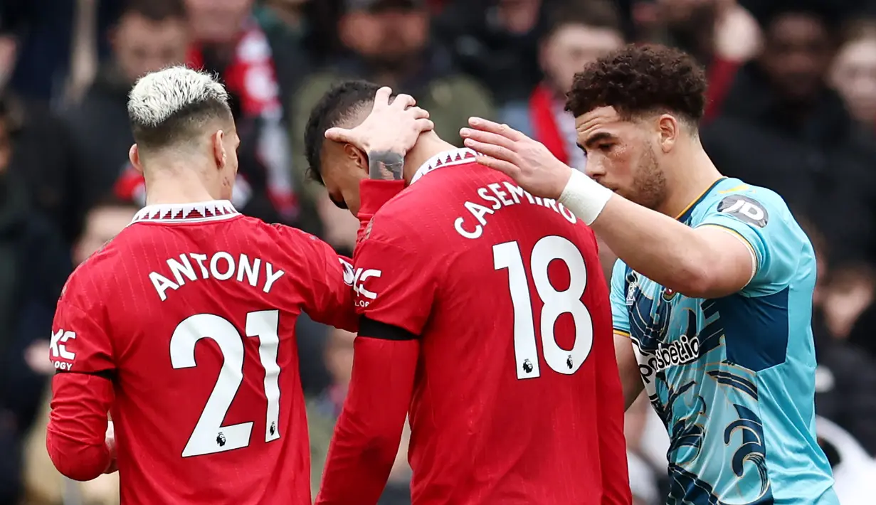 Pemain Manchester United, Antony dan pemain Soouthampton, Che Adams, berusaha menenangkan Casemiro setelah menerima kartu merah saat pertandingan melawan Southampton pada laga Liga Inggris di Stadion Old Trafford, Minggu (12/3/2023). (AFP/Darren Staples)