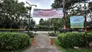 Spanduk terpasang di taman saat pemberlakuan karantina wilayah skala kecil atau mini lockdown di RT 011 RW 009, Kelurahan Kayu Putih, Pulogadung, Jakarta Timur, Minggu (6/6/2021). Sebanyak 14 warga positif COVID-19 saat ini telah dibawa ke RSD Wisma Atlet Kemayoran. (merdeka.com/Iqbal S. Nugroho)