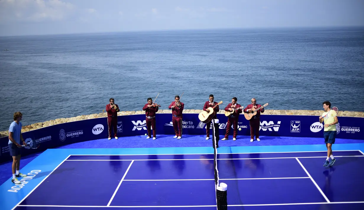 Musikus Mariachi tampil saat pertandingan tenis antara petenis Austria Dominic Thiem melawan petenis Jerman Alexander Zverev di Acapulco, Meksiko (26/2). Pertandingan ini digelar jelang mulainya turnamen tenis ATP 500 Meksiko. (AFP Photo/Pedro Pardo)