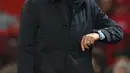 Pelatih Tottenham Hostpur, Jose Mourinho melihat jam tangannya saat pertandingan melawan Manchester United pada lanjutan Liga Inggris di Old Trafford, Rabu (4/12/2019). Mourinho gagal mengalahkan Manchester United mantan klub yang pernah dilatihnya. (AFP Photo/Oli Scarff)