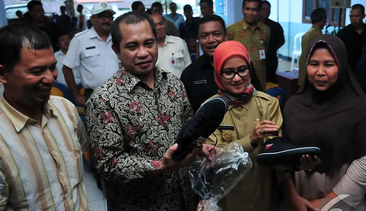 Menteri Desa, Pembangunan Daerah Tertinggal dan Transmigrasi, Marwan Jafar memberikan sepatu saat blusukan perdananya di Kabupaten Lebak, Banten, Rabu (5/11/2014) (Liputan6.com/Johan Tallo)