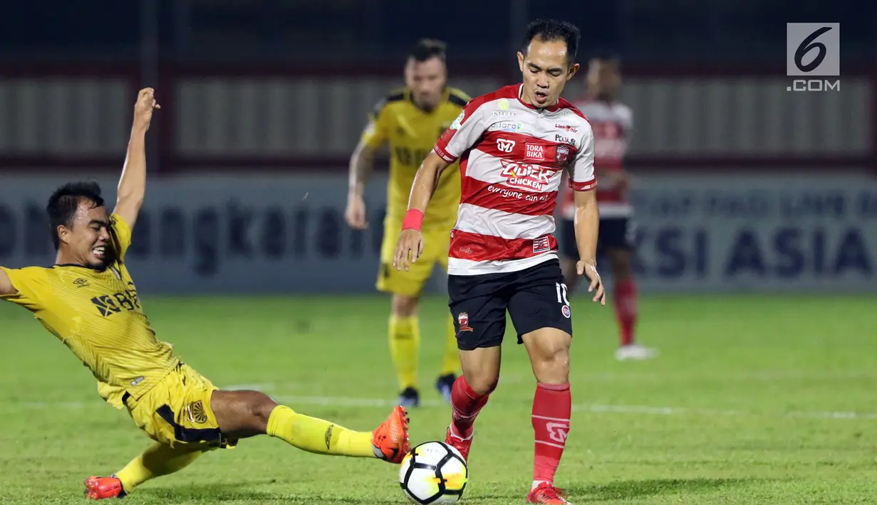 Bek Bhayangkara FC, M Fatcu Rochman (kiri) berusaha menahan pemain Madura United, Slamet Nurcahyono pada lanjutan Go-Jek Liga 1 Indonesia 2018 bersama Bukalapak di Stadion PTIK, Jakarta, Kamis (7/6). (Liputan6.com/Helmi Fithriansyah)