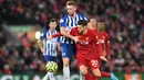 Gelandang Liverpool, Adam Lallana, berebut bola dengan gelandang Brighton, Dale Stephens, pada laga Premier League di Stadion Anfield, Liverpool, Sabtu (1/12). Liverpool menang 2-1 atas Brighton. (AFP/Paul Ellis)