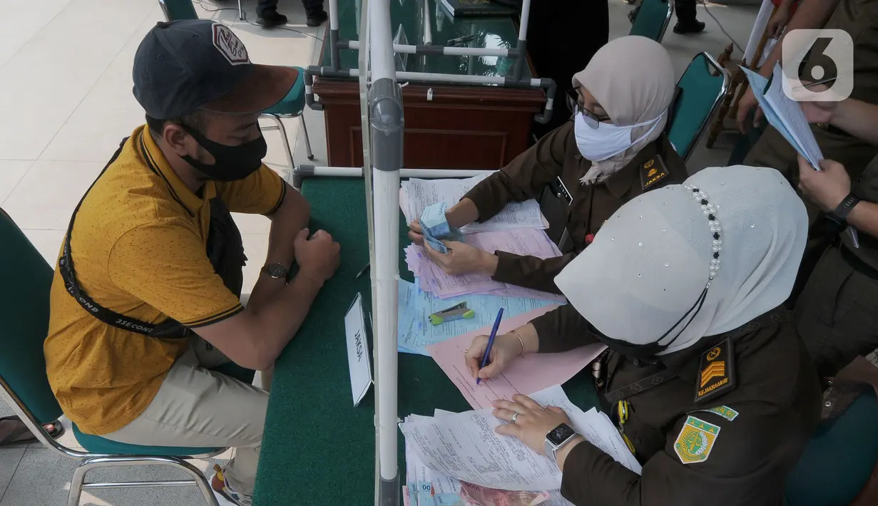 Pelanggar membayar denda saat Sidang Tipiring PPKM Darurat di kantor Kecamatan Pamulang, Tangerang Selatan, Banten, Senin (19/7/2021). Dua puluh empat pelanggar PPKM Darurat diantaranya tidak bermasker dan jam operasional tempat usaha didenda Rp 100 ribu hingga Rp 500 ribu. (merdeka.com/Arie Basuki)