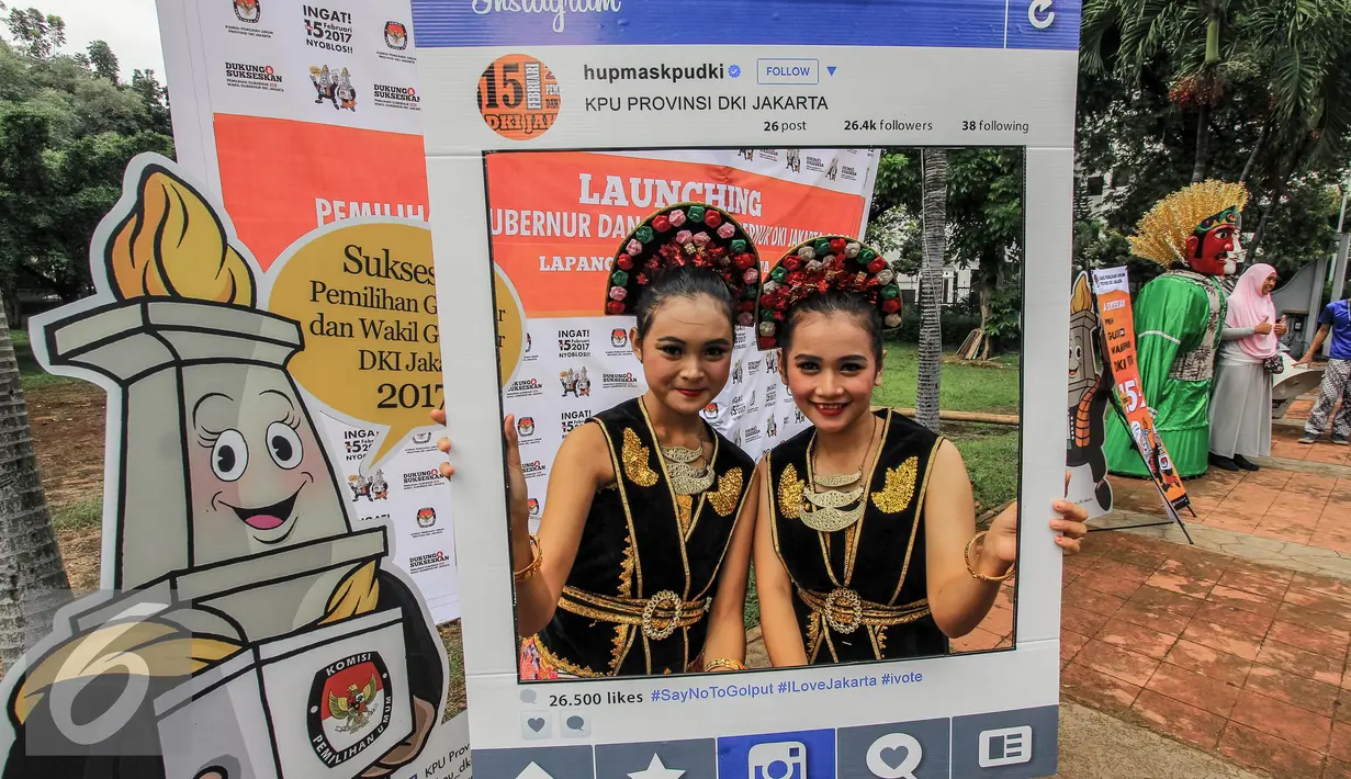 Warga berfoto menggunakan atribut saat launching pemilihan Gubernur dan Wakil Gubernur 2017 di Jakarta, Minggu (18/9). Launching tersebut bertujuan untuk mengedukasi masyarakat Jakarta menjelang Pilkada 2017. (Liputan6.com/Faizal Fanani)