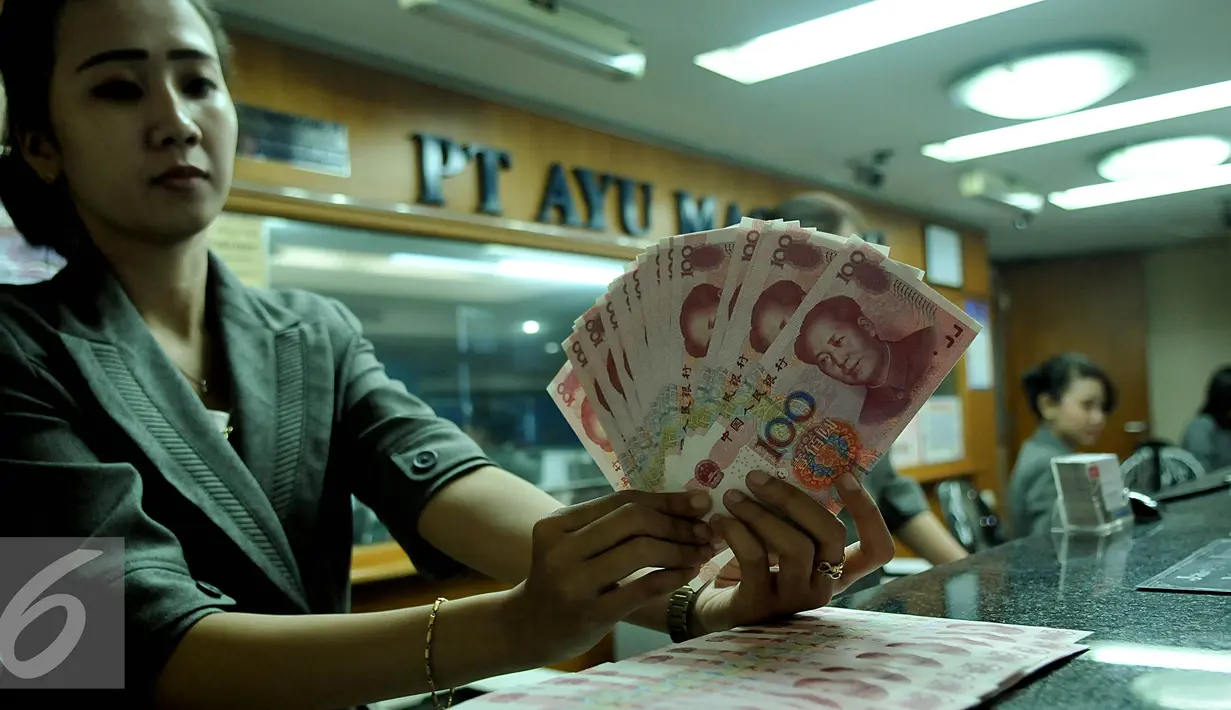 Petugas menunjukkan uang pecahan 100 Yuan di tempat penukaran uang, Jakarta, Kamis (13/8/2015). Kebijakan Tiongkok yang sengaja melemahkan (devaluasi) mata uang Yuan membuat Rupiah melemah terhadap dolar AS. (Liputan6.com/Johan Tallo)