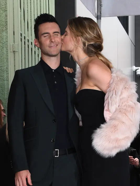 Adam Levine dicium sang istri Behati Prinsloo setelah dia dianugerahi Bintang di Hollywood Walk of Fame di Hollywood, California, pada 10 Februari 2017. Saat ini sang istri, Behati Prinsloo dikabarkan tengah mengandung anak ketiga mereka. (AFP/Mark Ralston)