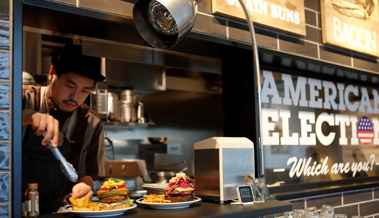 Koki J.S. Burgers Cafe, Yasuhito Fukui menyiapkan Mr. and Mrs. Burger bertema Capres AS Hillary Clinton dan Donald Trump di hamburger joint, Jepang (7/10). (REUTERS/Megumi Lim)