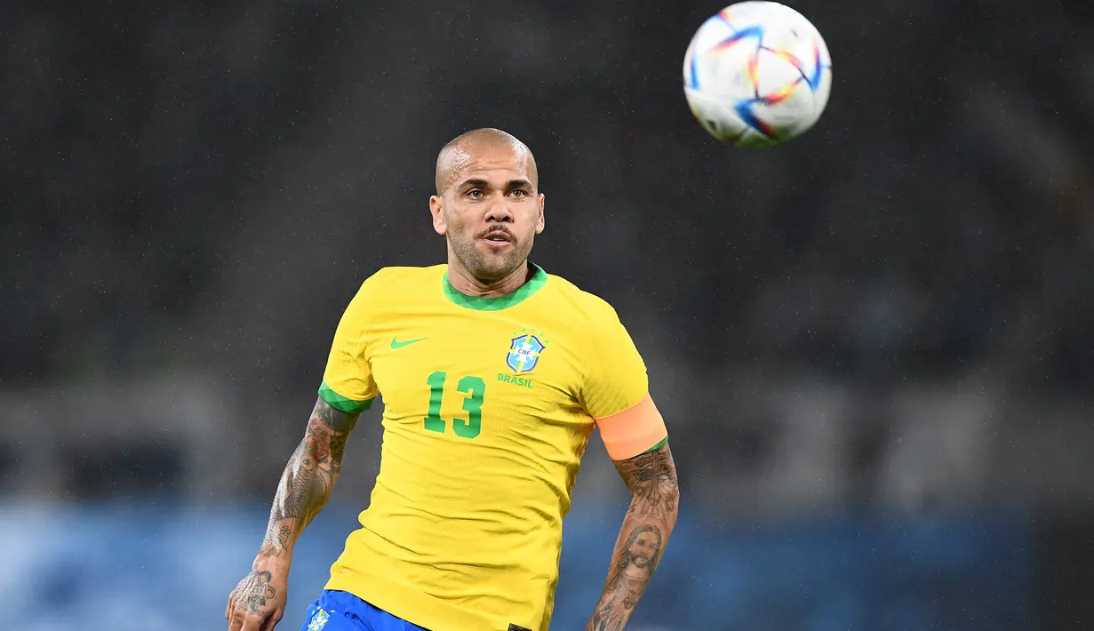 Dari segi jumlah penampilan bersama Timnas Brasil, Dani Alves juga akan mencetak rekor jika diturunkan di Qatar nanti. Hingga kini ia telah mengoleksi 124 caps dan berpeluang menyamai bahkan menggeser rekor Roberto Carlos dari posisi kedua dengan total 125 caps. Posisi puncak masih dipegang oleh Cafu dengan total 143 caps. (AFP/Charly Triballeau)