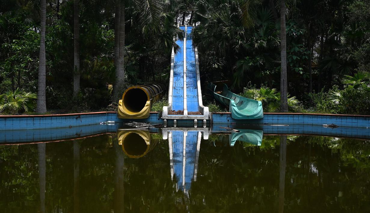 Foto pada 27 April 2019 memperlihatkan seluncuran air telantar di Taman Air Ho Thuy Tien yang telah lama ditinggalkan di kota Hue, Vietnam. Saat mengunjunginya, taman air ini tampak ditinggalkan, tak terurus, dan terkesan angker. (Manan VATSYAYANA/AFP)
