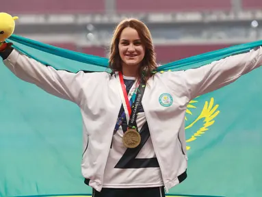 Atlet lompat tinggi Kazakhstan, Nadezhda Dubovitskaya mengibarkan bendera di podium setelah berhasil meraih perunggu di Asian Games 2018 di Jakarta, Kamis (30/8). (AP Photo/Bernat Armangue)