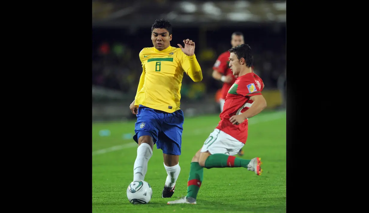 Pemain Timnas Brasil U-20, Casemiro (kiri) berebut bola dengan pemain Portugal U-20, Mario Rui pada pertandingan final Piala Dunia U-20 2011 yang berlangsung di El Campin, Bogota, Kolombia, Sabtu (20/8/2011). (AFP/Eitan Abramovic)