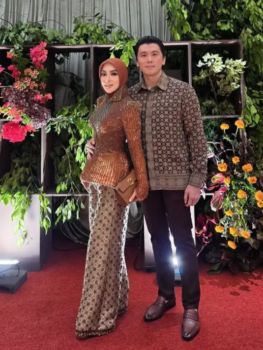 Atasan dipadukan dengan celana panjang songket yang serasi dengan kemeja suaminya.  [@princessyahrini]