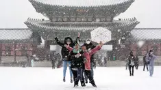 Pengunjung berswafoto di tengah salju di Istana Gyeongbok, istana kerajaan utama selama Dinasti Joseon dan salah satu landmark terkenal Korea Selatan di Seoul, Korea Selatan, 15 Desember 2022. (AP Photo/Ahn Young-joon)