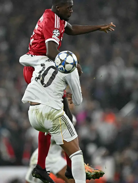 Bek Liverpool asal Prancis, Ibrahima Konate berebut bola dengan penyerang Real Madrid asal Prancis, Kylian Mbappe dalam pertandingan pekan keempat Liga Champions 2025-2026 di Stadion Anfield, Inggris, pada Selasa 4 November 2025 waktu setempat atau Rabu (5/11/2025) dini hari WIB. Sampai waktu turun minum, skor 0-0 tetap bertahan meski kedua tim bergantian mengancam. (Paul ELLIS/AFP)