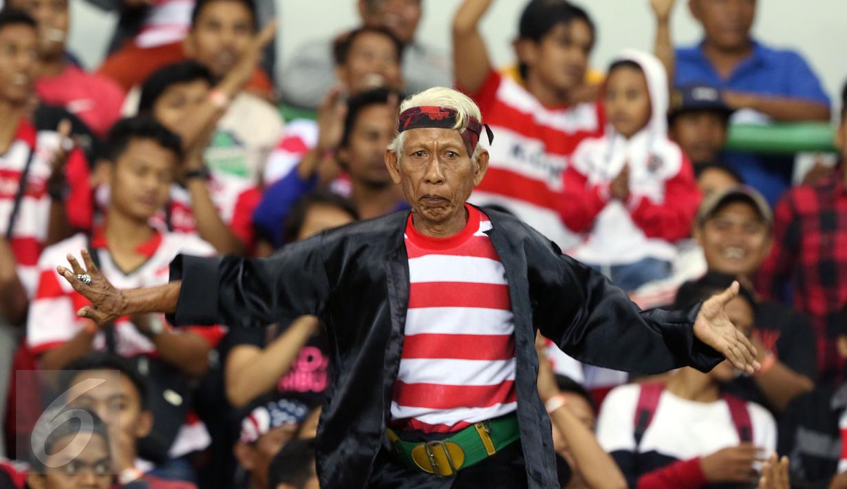 Suporter Madura United menari jelang menyaksikan timnya berlaga melawan Persija pada lanjutan Liga 1 di Stadion Patriot Candrabhaga, Bekasi, Kamis (4/5). Madura United FC unggul 1-0. (Liputan6.com/Helmi Fithriansyah)