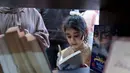 Perpustakaan yang terletak di lingkungan Rimal, Kota Gaza, menjadi ruang belajar alternatif, dan harapan di tengah kehancuran akibat serangan Israel sejak Oktober 2023. Tampak dalam foto, seorang gadis pengungsi Palestina membaca buku di perpustakaan Al-Ankaa (Phoenix), perpustakaan pertama yang dibuka sejak gencatan senjata di Jalur Gaza yang berisi buku-buku yang diselamatkan dari perpustakaan yang hancur selama perang Israel-Hamas, di lingkungan Rimal, Kota Gaza pada Selasa 21 April 2026. (Omar AL-QATTAA/AFP)
