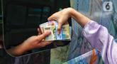 Warga menukarkan uang tunai baru di layanan kas keliling Bank Indonesia di Pasar Kopro, Jakarta Barat, Rabu (29/3/2023). (Liputan6.com/Angga Yuniar)