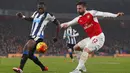 Striker Arsenal, Olivier Giroud, dihadang pemain Newcastle, Chancel Mbemba, ketika akan mengirim umpan pada laga Liga Premier Inggris. Berkat kemenangan itu Arsenla kian kokoh di puncak klasemen. (Reuters/Eddie Keogh)