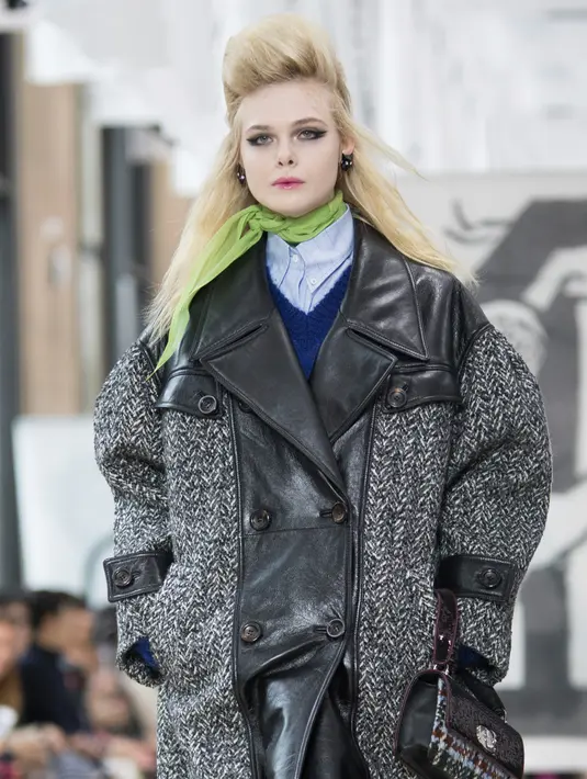 Aktris Elle Fanning membawakan busana karya Miu Miu pada pagelaran Paris Fashion Week Fall-Winter 2018, Selasa (6/3). Ini merupakan aksi catwalk pertama Elle Fanning menyusuri panggung pekan mode. (Vianney Le Caer/Invision/AP)