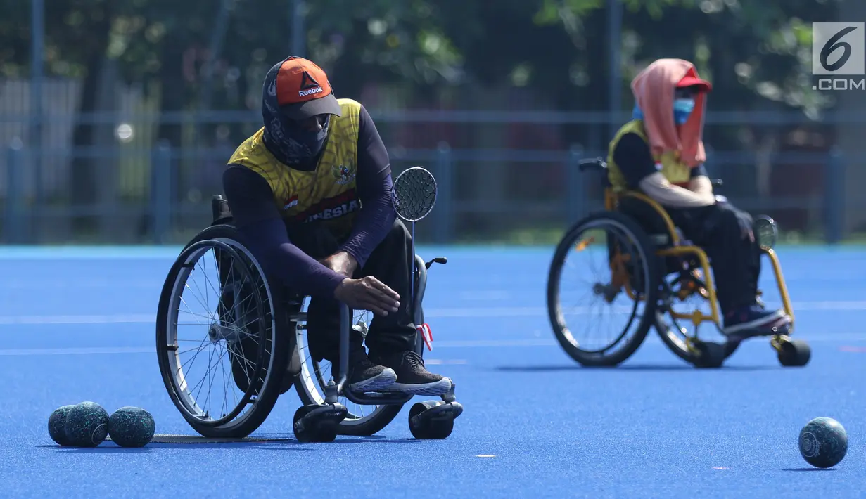 Atlet Para Games Indonesia cabang olahraga Lawn Bowls melakukan lemparan saat latihan di Lapangan Hoki Kompleks GBK, Jakarta, Selasa (18/9). Latihan ini adaptasi lapangan sekaligus persiapan jelang Asian Para Games 2018. (Liputan6.com/Helmi Fithriansyah)