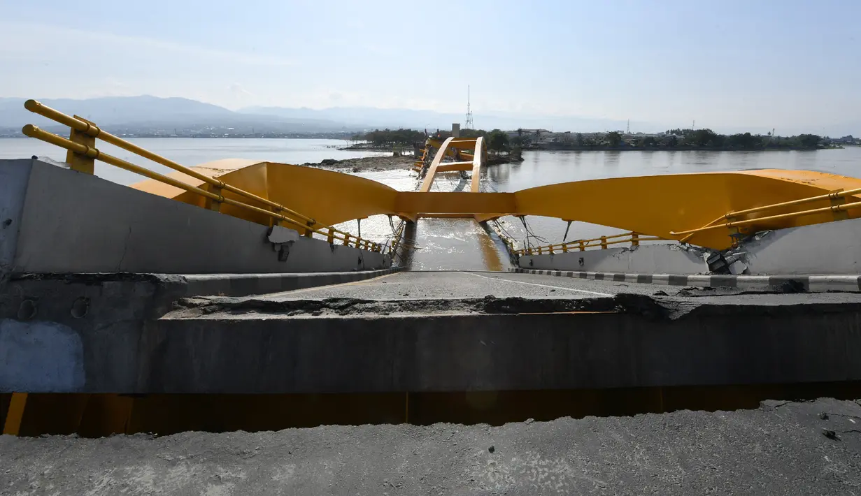 Salah satu landmark Kota Palu, Jembatan Kuning yang ambruk akibat gempa dan tsunami di Sulawesi Tengah, Rabu (3/10). Jembatan kuning ini merupakan jembatan lengkung pertama di Indonesia. (AFP PHOTO / ADEK BERRY)