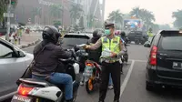 Personel Polresta Pekanbaru membagikan masker kepada pengguna jalan agar tidak menghirup kabut asap. (Liputan6.com/M Syukur)