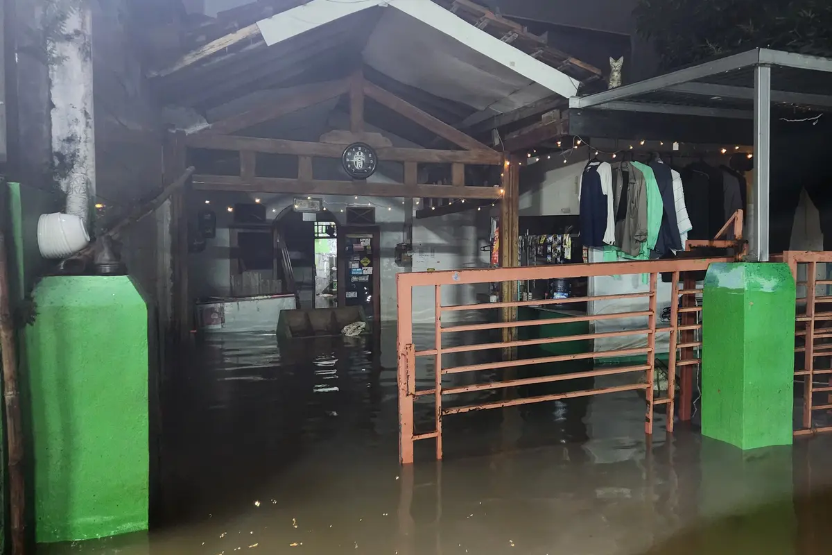 Banjir di Perumahan Sawangan Asri akibat luapan air Kali Pesanggrahan, Sawangan, Depok, Minggu malam (9/3/2025). (Liputan6.com/Dicky Agung Prihanto)