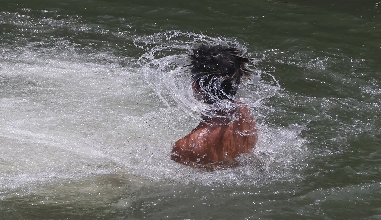 Seorang pemuda menyejukkan diri di perairan yang mengalir di Taman Tonkawa dekat Crawford, Texas, Jumat, 16 Juni 2023. Suhu diperkirakan akan mencapai angka 100 derajat Fahrenheit selama beberapa hari ke depan. (Rod Aydelotte/Waco Tribune-Herald via AP)