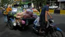 Seorang pedagang mengendarai kereta motornya yang berisi sayuran untuk dijual karena pasar tetap ditutup di tengah pembatasan lockdown yang diberlakukan untuk mencoba menghentikan lonjakan kasus virus corona COVID-19 di Phnom Penh, Kamboja, Selasa (11/5/2021). (TANG CHHIN Sothy/AFP)
