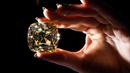 <p>'The Red Cross Diamond', sebuah berlian mewah berwarna kuning pekat berbentuk bantal dengan berat 205,07 karat yang akan ditawarkan oleh Rumah Lelang Christie di Jenewa, Swiss, 11 Mei 2022. Sebagian dari hasil penjualan berlian akan disumbangkan kepada Komite Palang Merah Internasional. (Fabrice COFFRINI/AFP)</p>